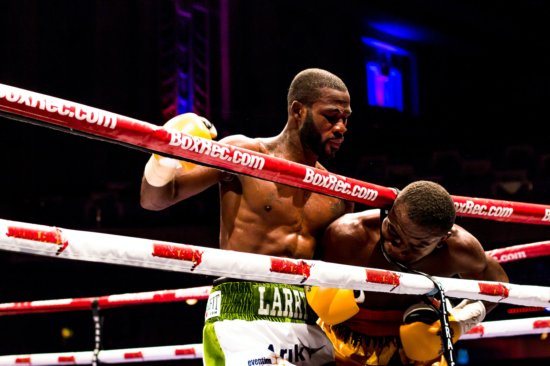 Un combat de boxe sur un ring au corps à corps.