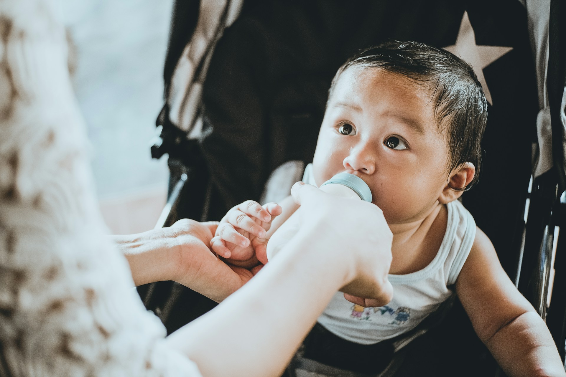 Un petit nouveau-né boit du lait par la main de sa mère.