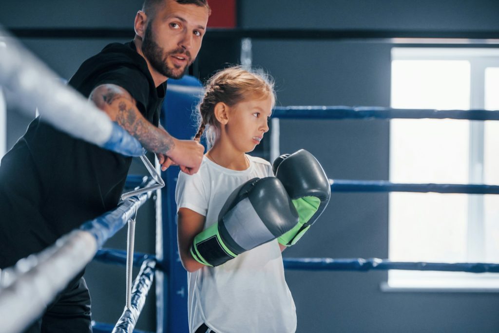 Un entraîneur de sport coach une jeune femme sur le ring.
