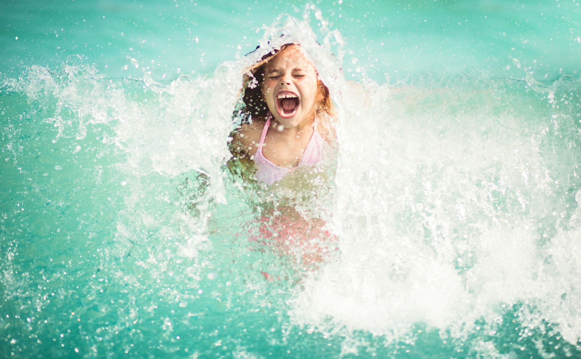 Une jeune nageuse s'amuse dans un bassin.
