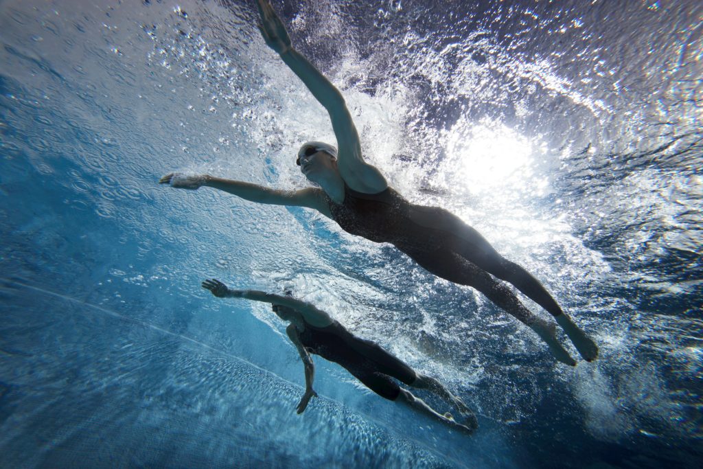 Des femmes nagent dans un bassin sportif.