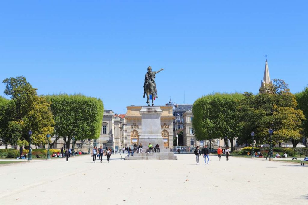 Vue d'une statue de Louis XIV sous un ciel azur.