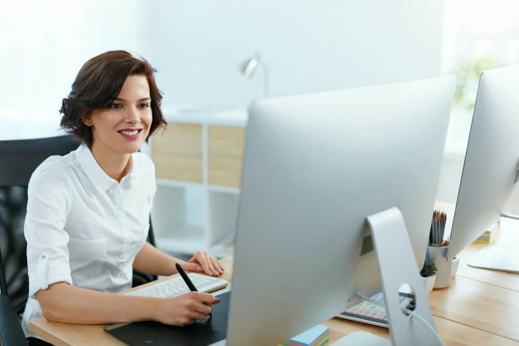 Photo d'une employée au travail, devant son écran d'ordinateur.