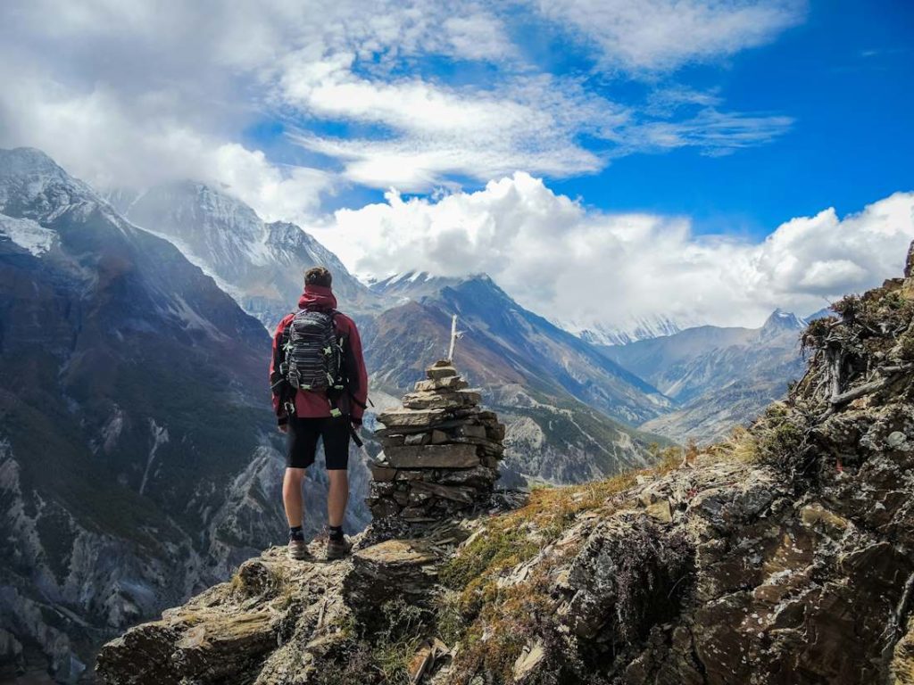 Un randonneur en haut d'un sommet, admirant une vue dégagée.