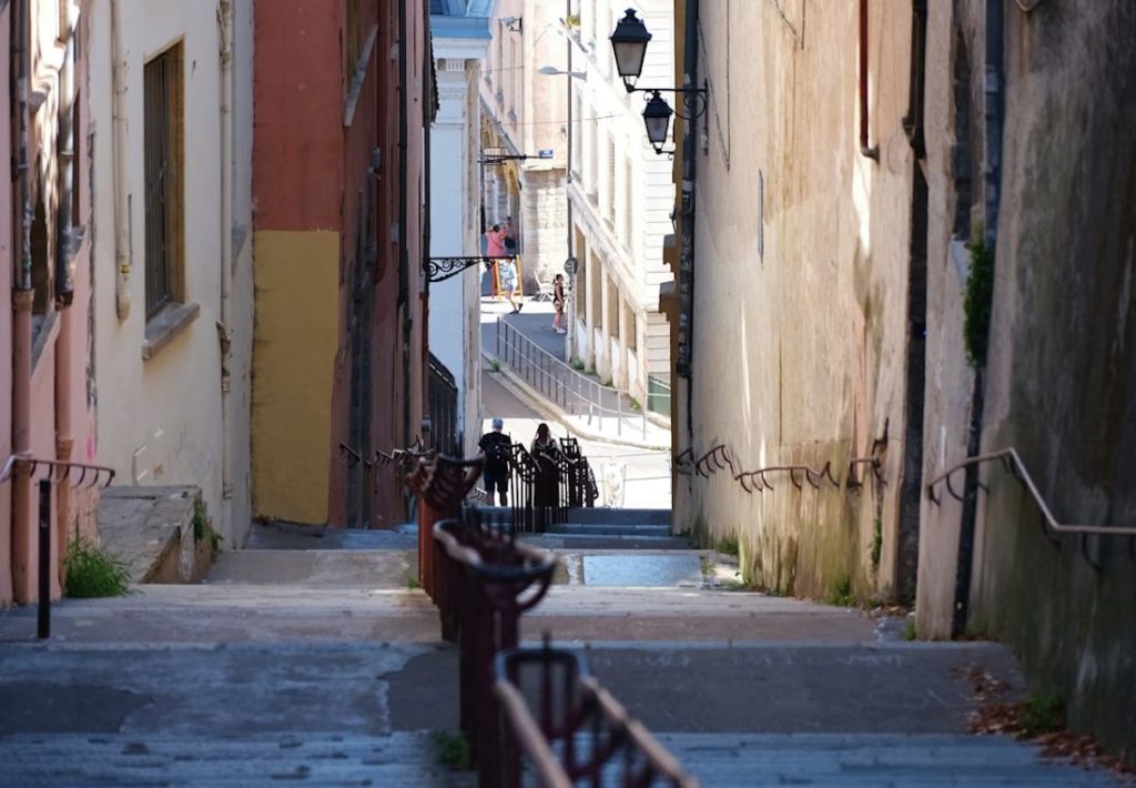 Vue du haut d'un escalier dans une ruelle colorée.