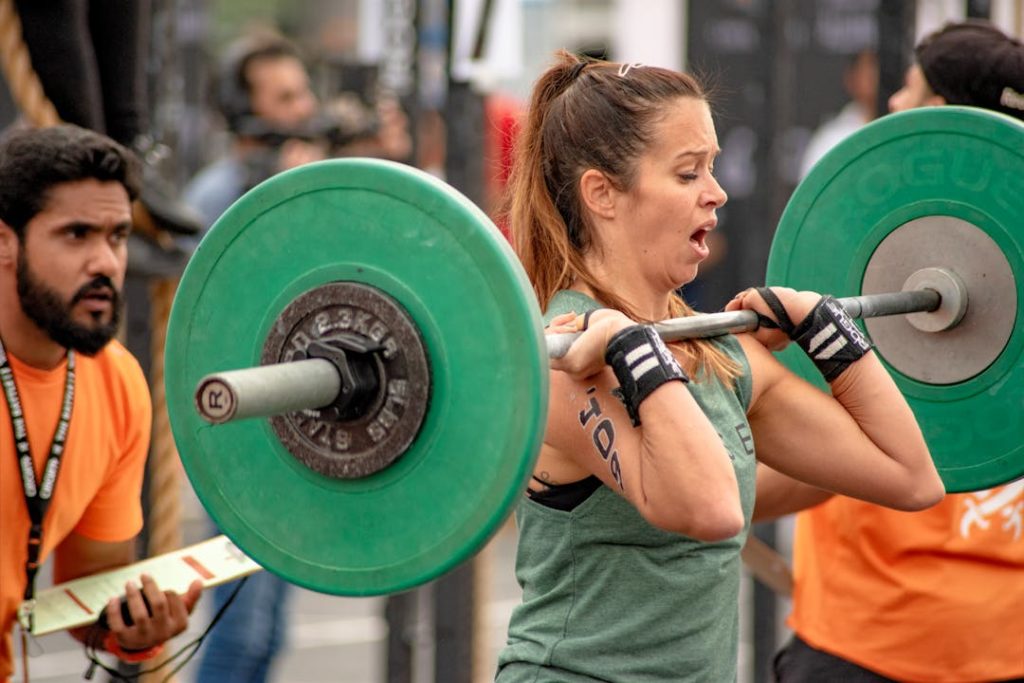 Une femme soulève des poids à la barre dans une salle de sport.