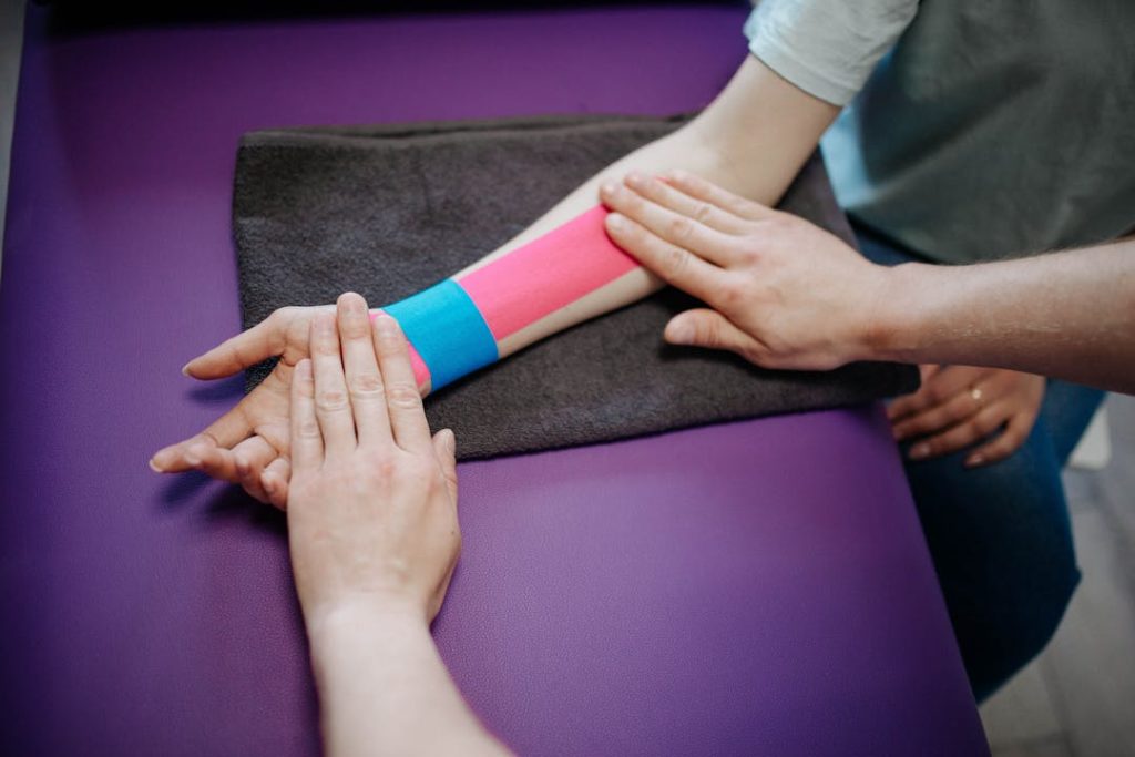 Un bras droit posé au sol avec des bandes de couleur collées à la peau.