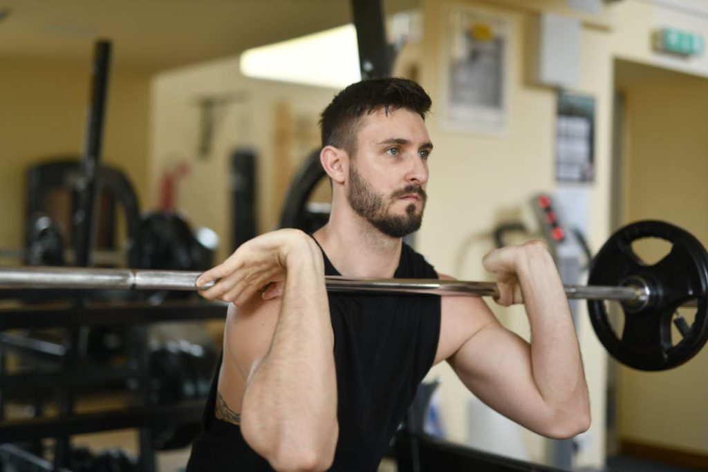 Un sportif en train d'effectuer un front squat avec une barre d'haltères.