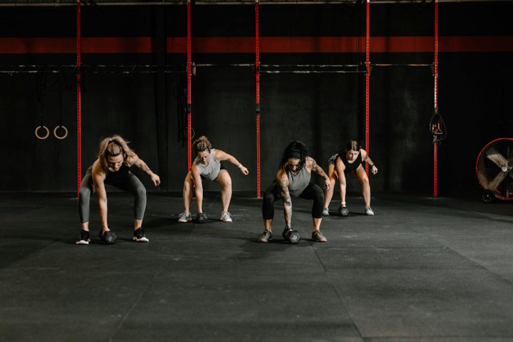 Un groupe de participants font du sport dans une salle de muscu.