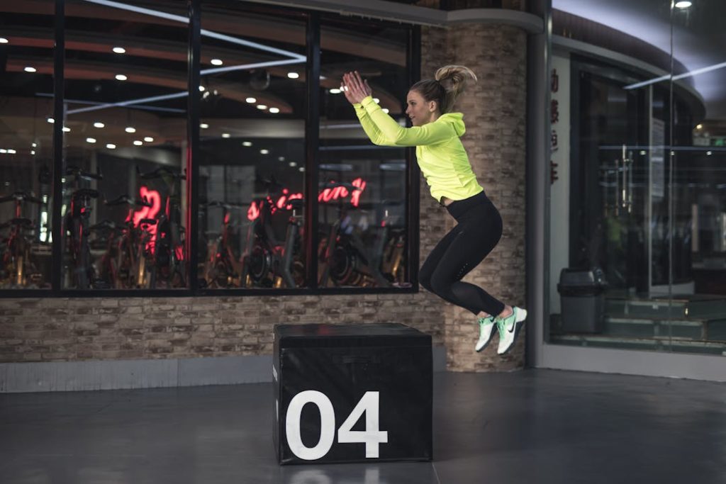 Une femme photographiée lors d'un saut sur un caisson de cross-training.