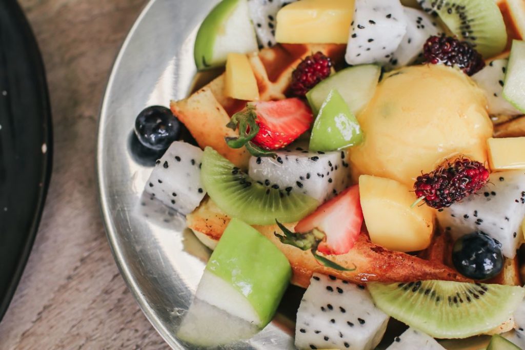 Un bol composé de fruits, de céréales et de yaourt.
