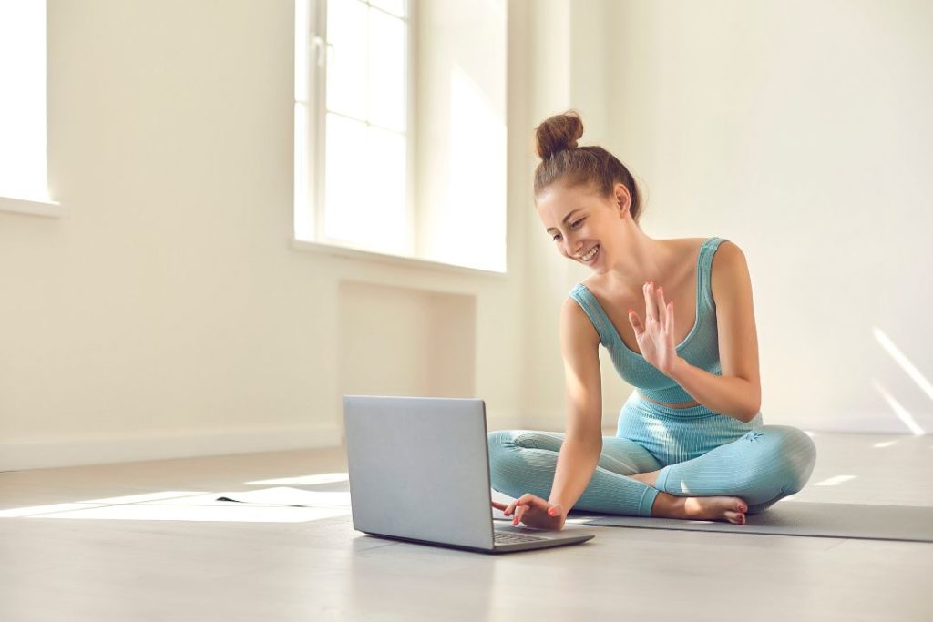 Une femme en train de faire du yoga en visio.