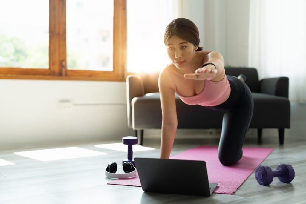 Une femme qui fait un cours de pilates en ligne.