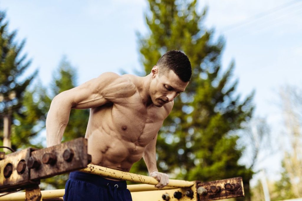 Un homme en train de faire des dips avec des barres parallèles.