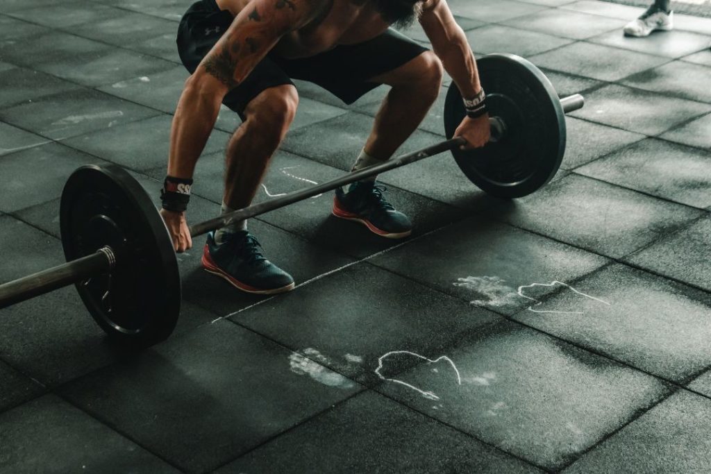 Un homme en train de soulever des poids en salle de sport.