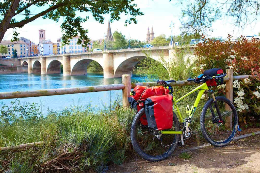 Un VTT posé sur un garde-corps en bois, au bord d'un fleuve.