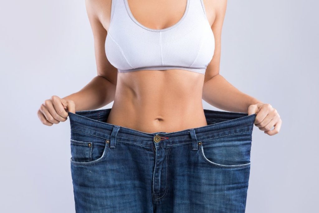 Une femme qui vient de perdre du poids dans un pantalon trop grand pour elle.