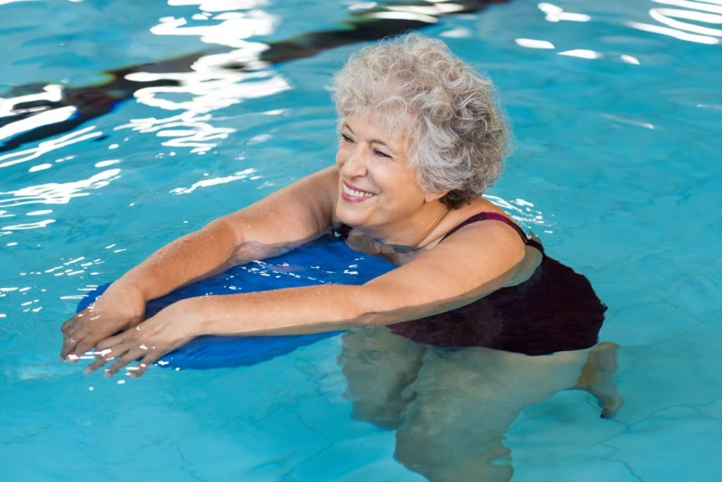 Une dame âgée qui fait un cours d'aquagym.